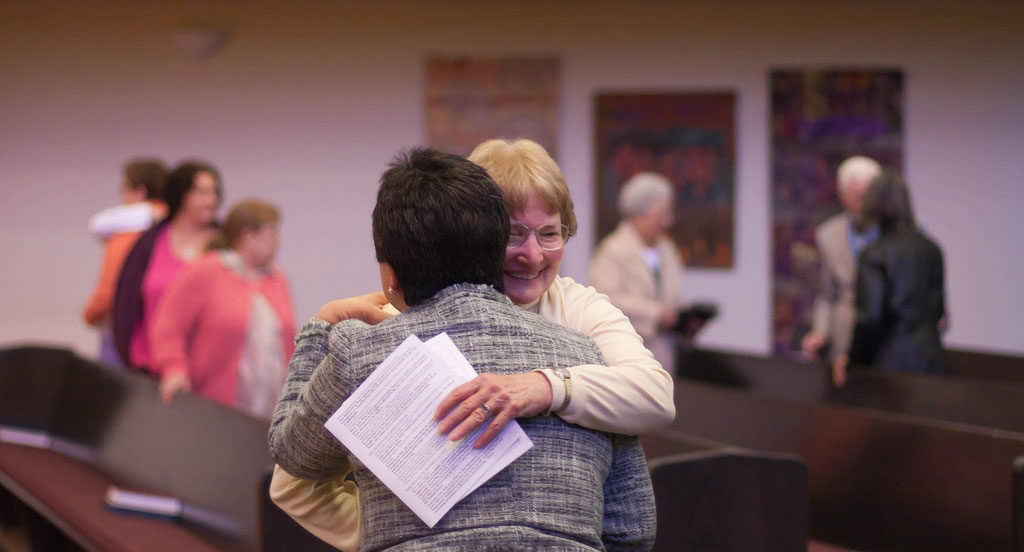 two women hugging after service