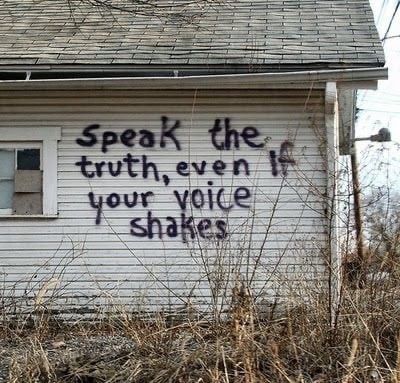 "Speak the truth, even if your voice shakes" spray painted on the side of a house.