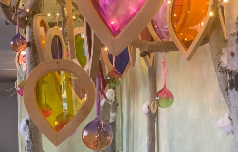 Photo of aspen forest art installation with Christmas ornaments hung on branches
