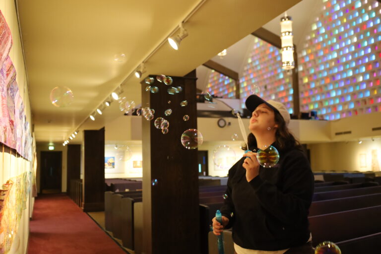 Olivia blowing bubbles in the First Church sanctuary.