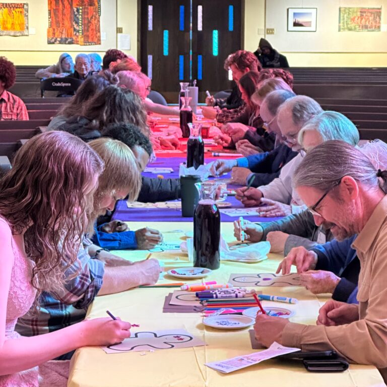 Members and friends of First Church doing art together in the sanctuary.