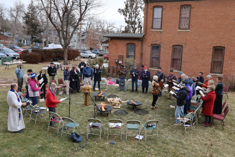 Congregation of First Church gathered around fire pits on the lawn for worship.