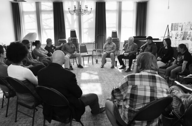 Black and white photo of illuminators hosting a circle discussion in the Parlor