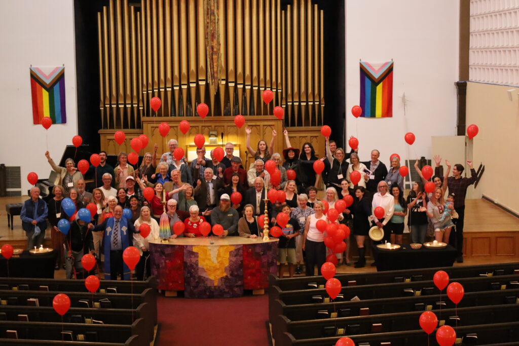 Congregation gathered around the altar with red balloons