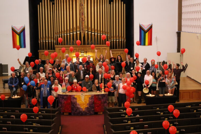 Congregation gathered around the altar with red balloons