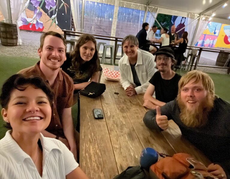 A group of friends, including Jalen Garza and TIR Kevin Lazarus, take a selfie while sharing a meal