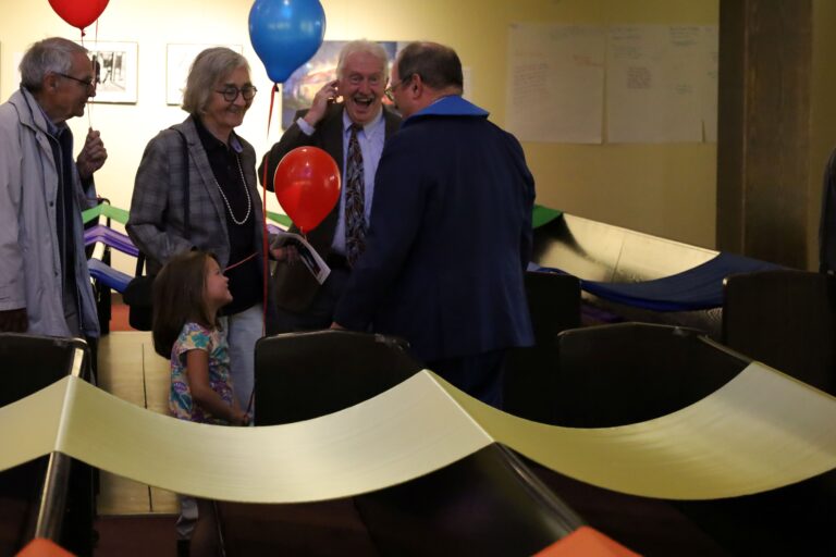 Group of people talking with Pastor Mike with balloons
