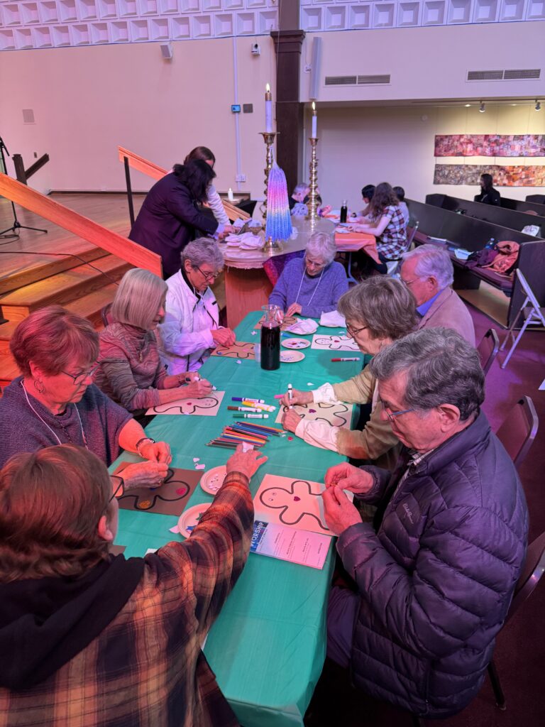 Group of First Church members doing a craft together at a table next to the altar.