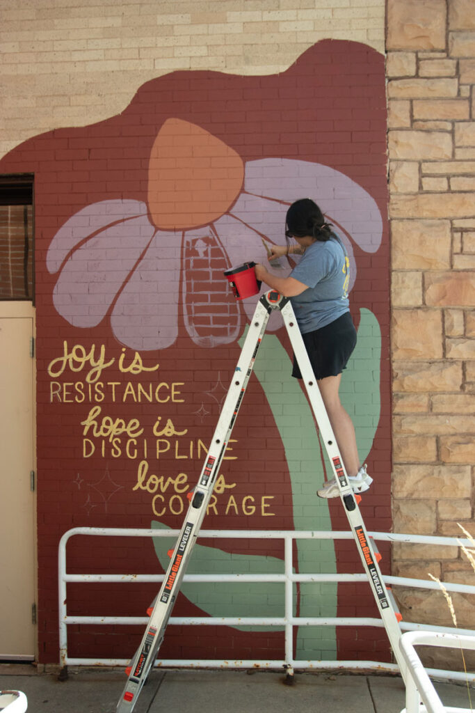 Woman panting mural on side of FUMC church