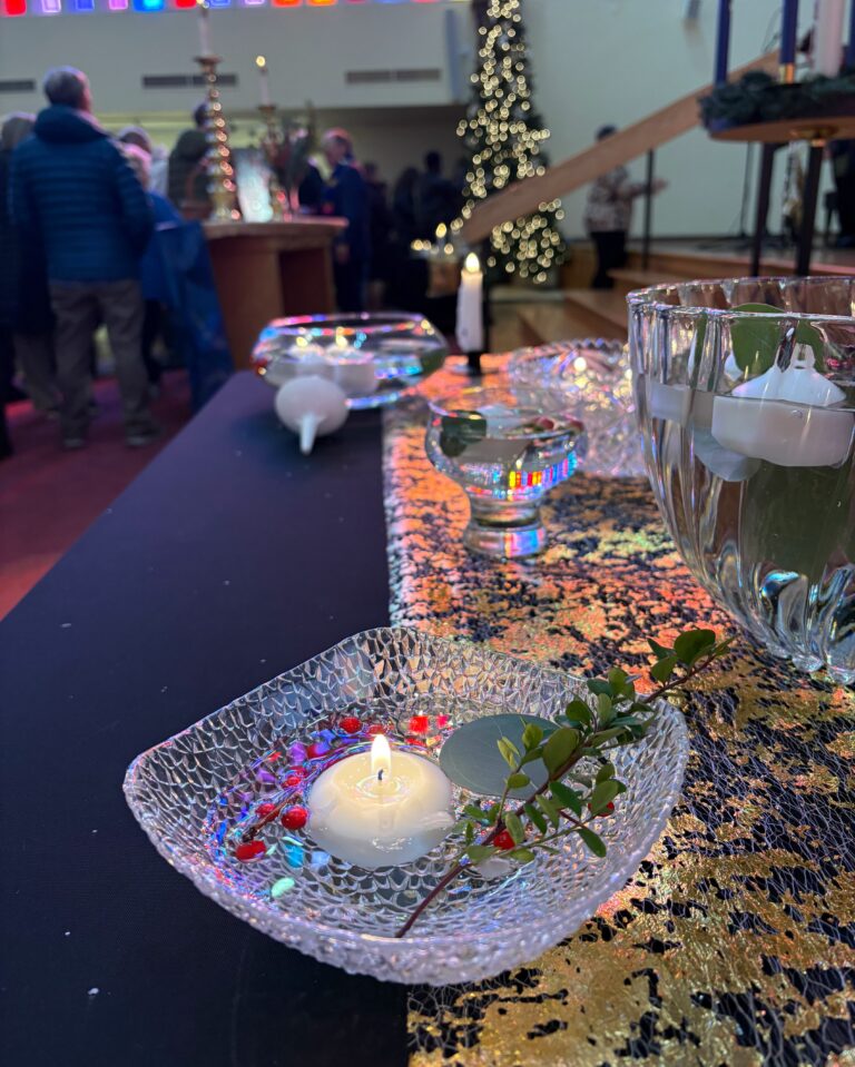 Candle table with Christmas tree in the background