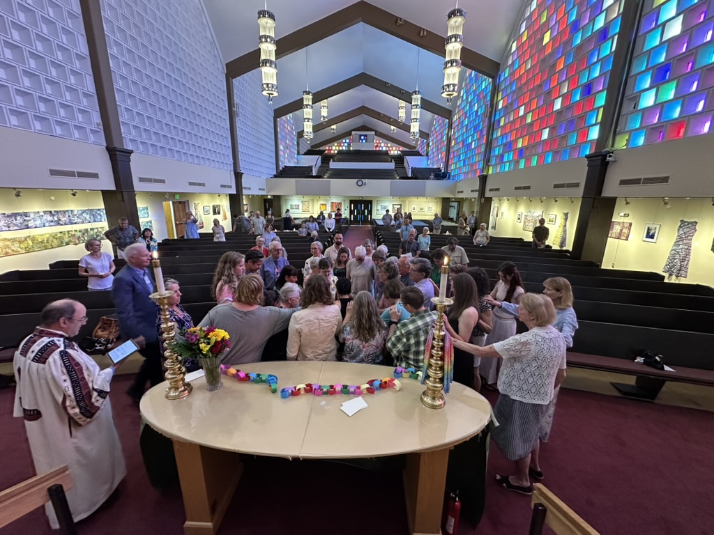 People of First Church praying with hands on each other's shoulders