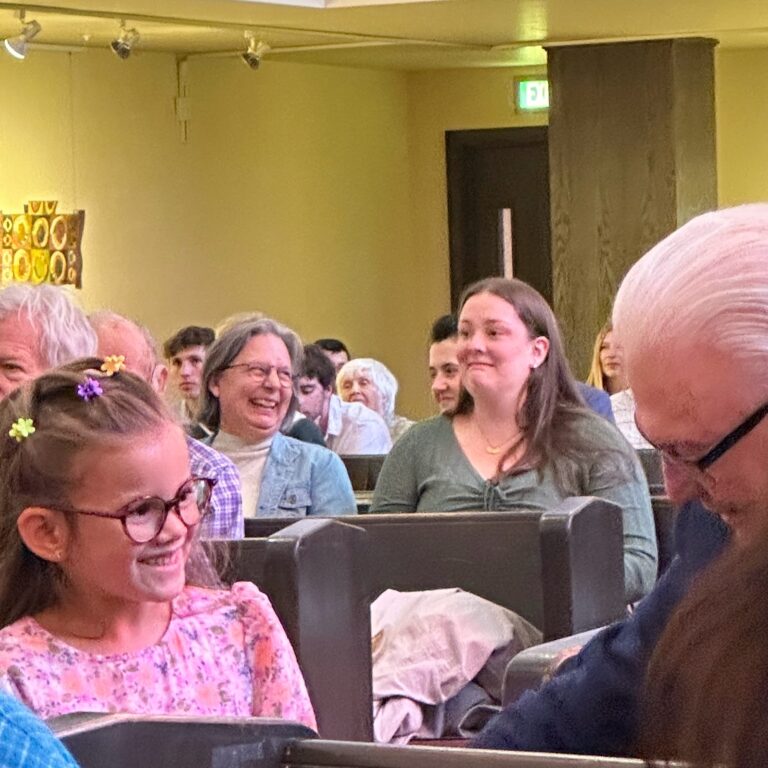 Child passing bread out to congregation members on Easter